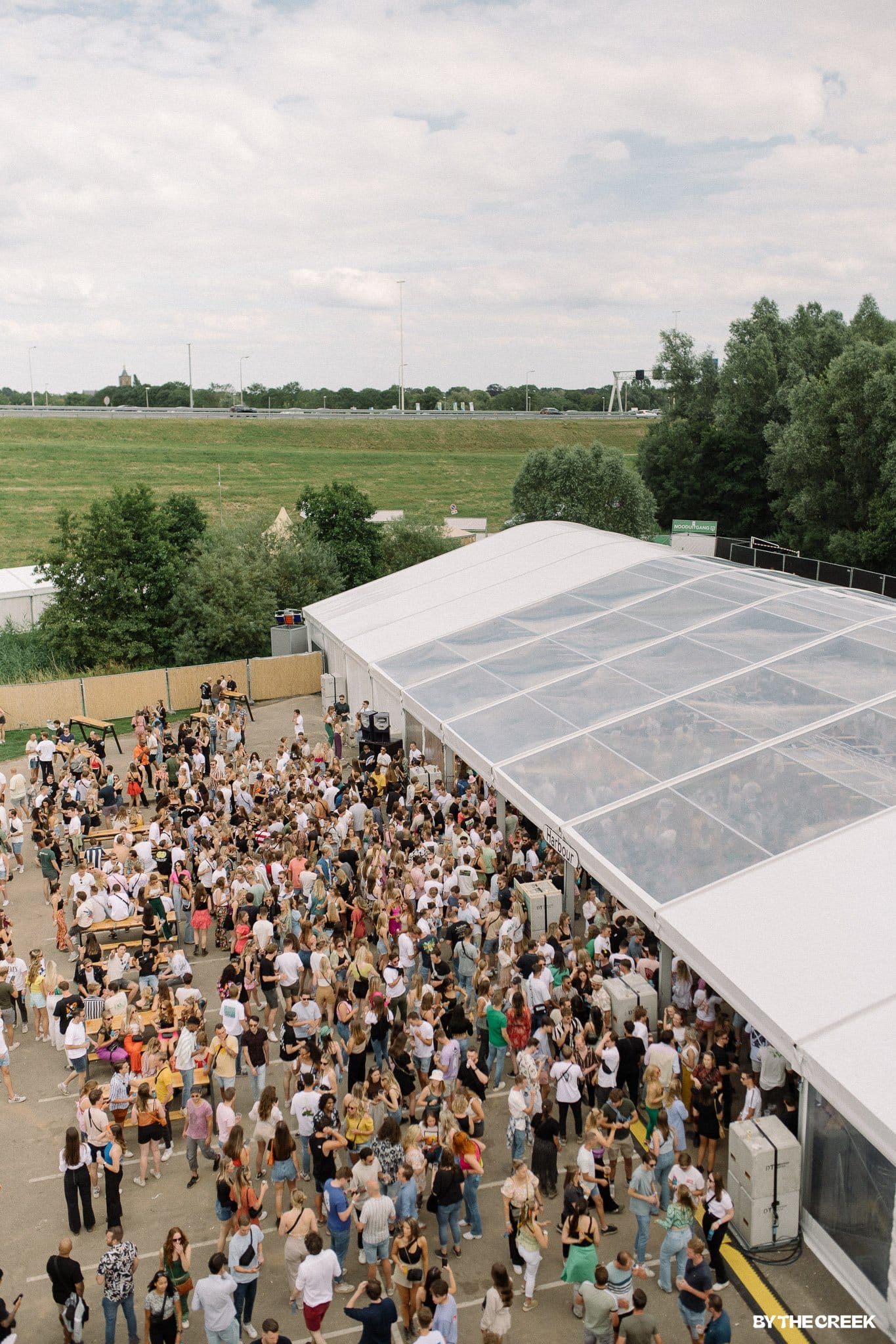 Aluhal van bovenaf, mensen lopen naar binnen en buiten.